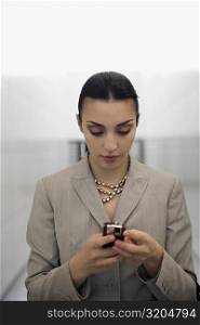 Close-up of a businesswoman text messaging at an airport