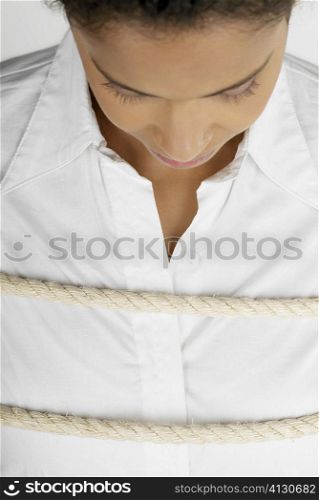 Close-up of a businesswoman tied up with a rope