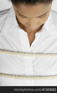 Close-up of a businesswoman tied up with a rope