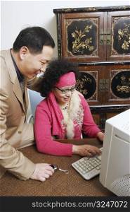 Close-up of a businesswoman using a computer with a businessman sitting beside her