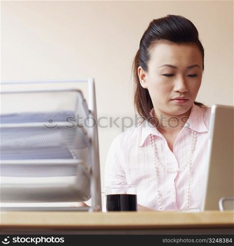 Close-up of a businesswoman using a laptop in an office