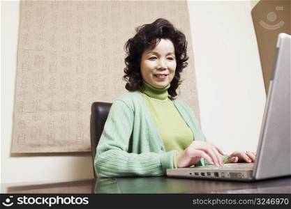 Close-up of a businesswoman using a laptop smiling