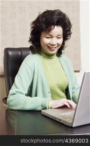 Close-up of a businesswoman using a laptop smiling