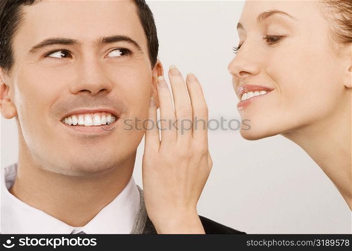 Close-up of a businesswoman whispering to a businessman