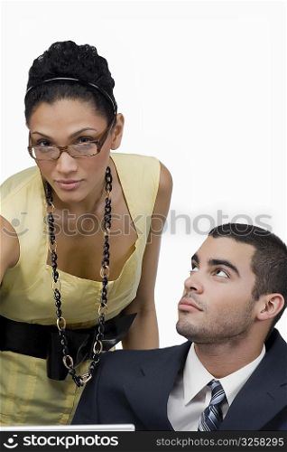 Close-up of a businesswoman with a businessman looking at her in an office