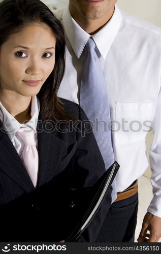 Close-up of a businesswoman with a businessman standing behind her