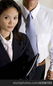 Close-up of a businesswoman with a businessman standing behind her