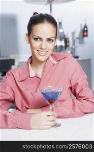 Close-up of a businesswoman with a glass of martini in a bar