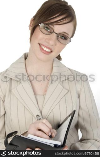 Close-up of a businesswoman writing in a personal organizer