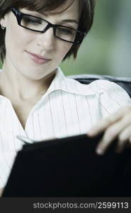 Close-up of a businesswoman writing on a file