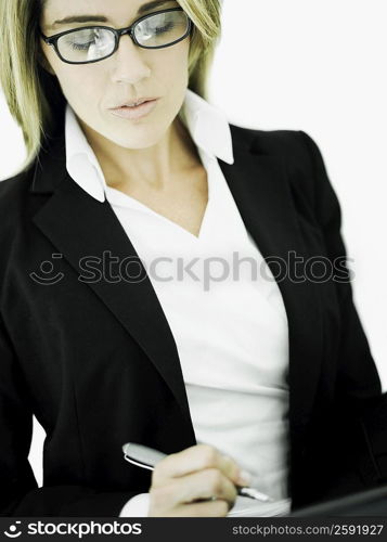 Close-up of a businesswoman writing with a pen