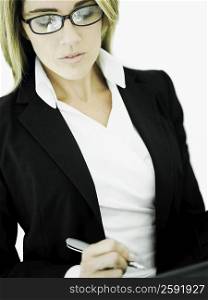 Close-up of a businesswoman writing with a pen