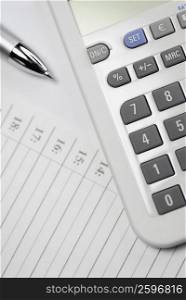 Close-up of a calculator and a pen