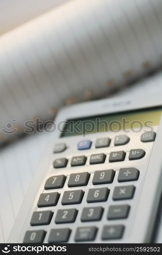 Close-up of a calculator on a spiral notebook