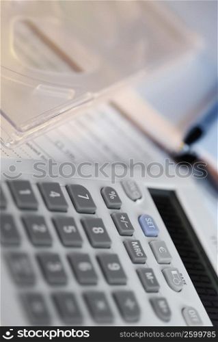 Close-up of a calculator with a pen on documents