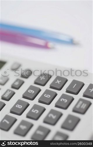 Close-up of a calculator with two pens