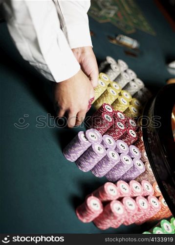 Close-up of a casino worker&acute;s hand arranging gambling chips on a gambling table