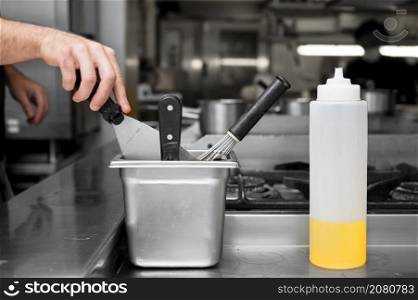 Close up of a chef using a spatula at a commercial kitchen. High quality photo. Close up of a chef using a spatula at a commercial kitchen.