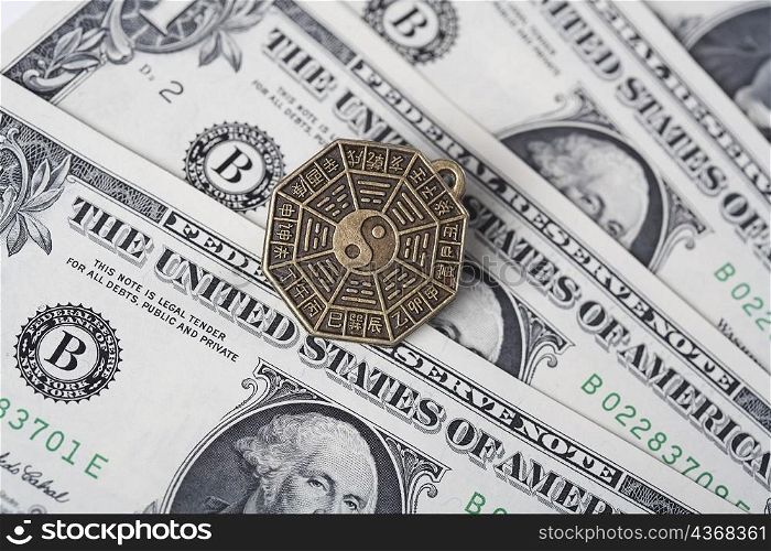 Close-up of a Chinese coin over US paper currency
