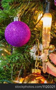 Close-up of a Christmas Tree decorated in a purple theme.
