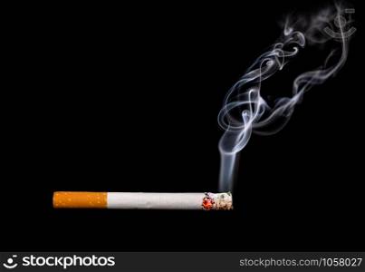Close up of a cigarette with smoke showing at black background
