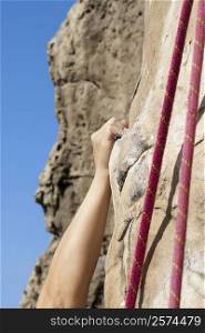 Close-up of a climber&acute;s hand scaling a rock face