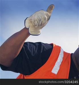 Close-up of a construction worker showing a thumbs up sign