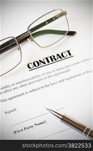 Close up of a contract ready to be signed.With pen and glasses.Office,legal concept.With vignette