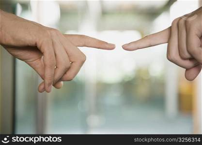 Close-up of a couple&acute;s fingers pointing towards each another