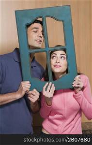 Close-up of a couple holding a window frame