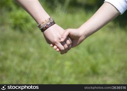 Close up of a couple holding hands outdoors