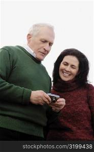 Close-up of a couple looking at a digital camera and smiling