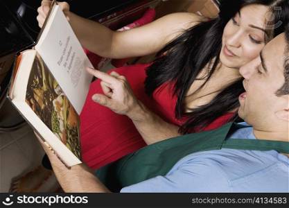 Close-up of a couple reading a cookbook in the kitchen