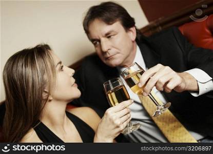 Close-up of a couple toasting with glasses of wine and looking at each other