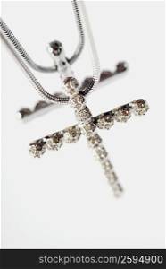 Close-up of a cross shaped pendant in a necklace