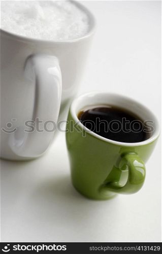 Close-up of a cup of black tea with a mug of coffee