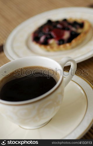 Close-up of a cup of black tea with a tart