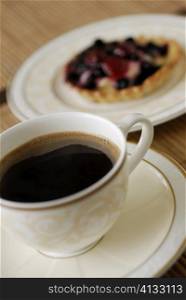 Close-up of a cup of black tea with a tart