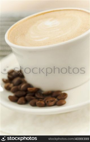 Close up of a cup of coffee latte with beans