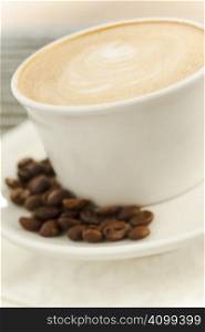 Close up of a cup of coffee latte with beans