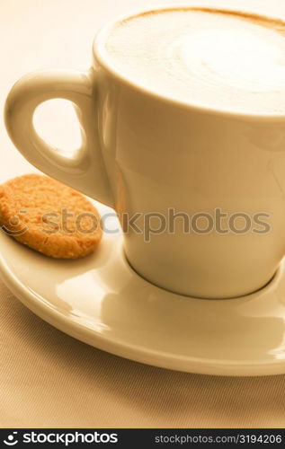 Close-up of a cup of coffee served with a cookie