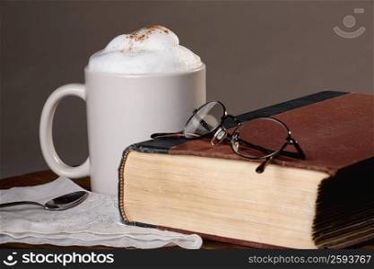 Close-up of a cup of coffee with a book