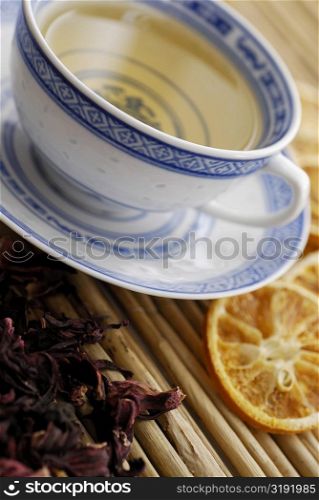 Close-up of a cup of herbal tea with dry herbal leaves