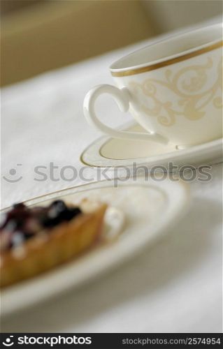 Close-up of a cup of tea with a fruit tart