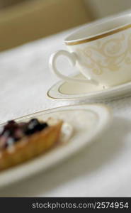 Close-up of a cup of tea with a fruit tart