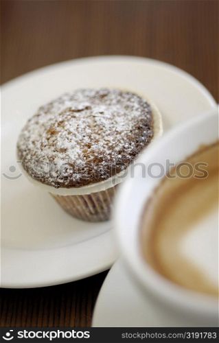 Close-up of a cupcake with a cup of tea