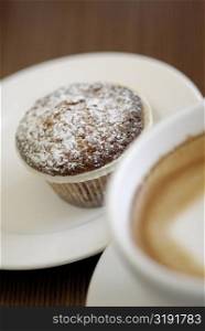 Close-up of a cupcake with a cup of tea