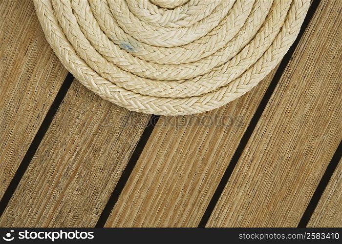 Close-up of a curled up rope on the deck of a sailboat