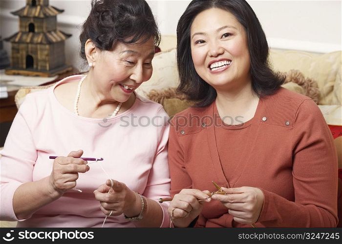 Close-up of a daughter and her mother knitting