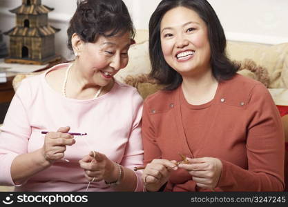 Close-up of a daughter and her mother knitting